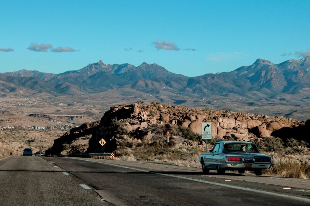 Image of a Nevada road sign with a car to symbolize driving in Nevada. — full coverage car insurance Nevada